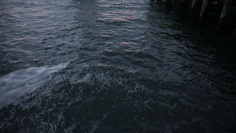 dark water of a harbor reflects the sunset