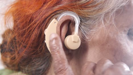 woman adjusting hearing aid