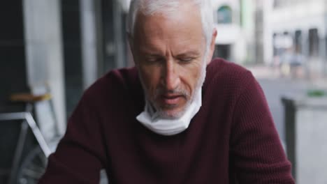 caucasian man out and about in a coffee wearing a face mask against coronavirus