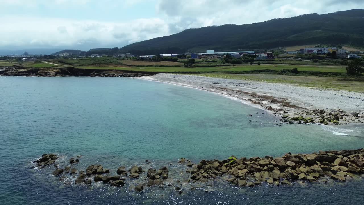 Una spiaggia tranquilla a Lugo, in Galizia, con costa rocciosa e onde delicate