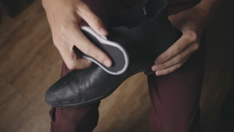 hombre lustrando sus zapatos - ángulo alto, primer plano