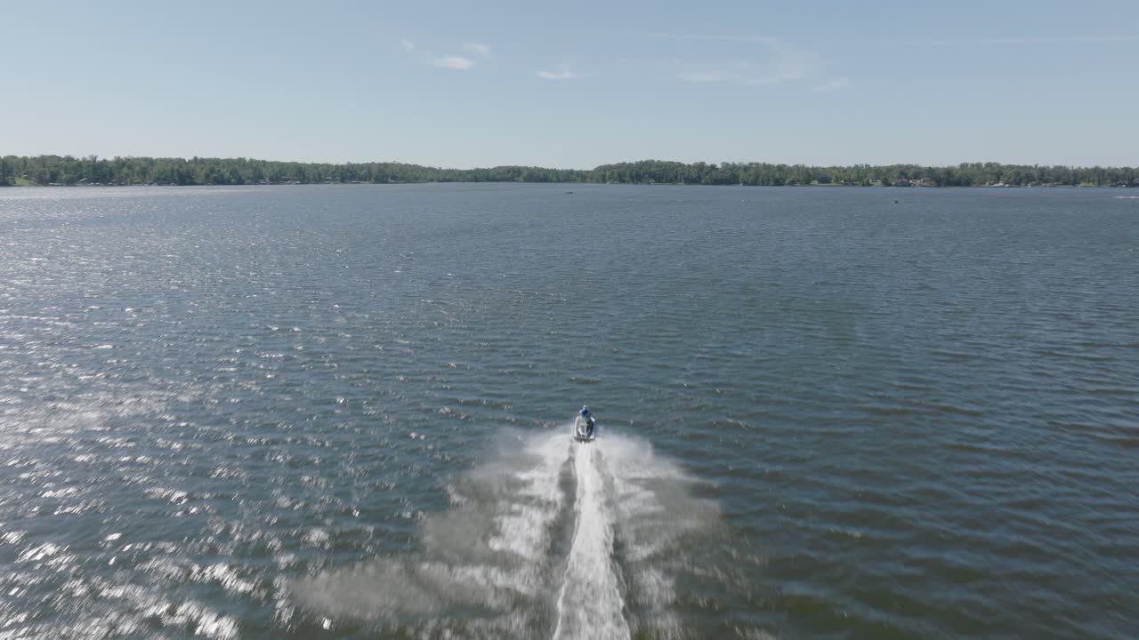 Drone footage of a jet ski cutting through the sparkling waters of Big Round Lake, Wisconsin.