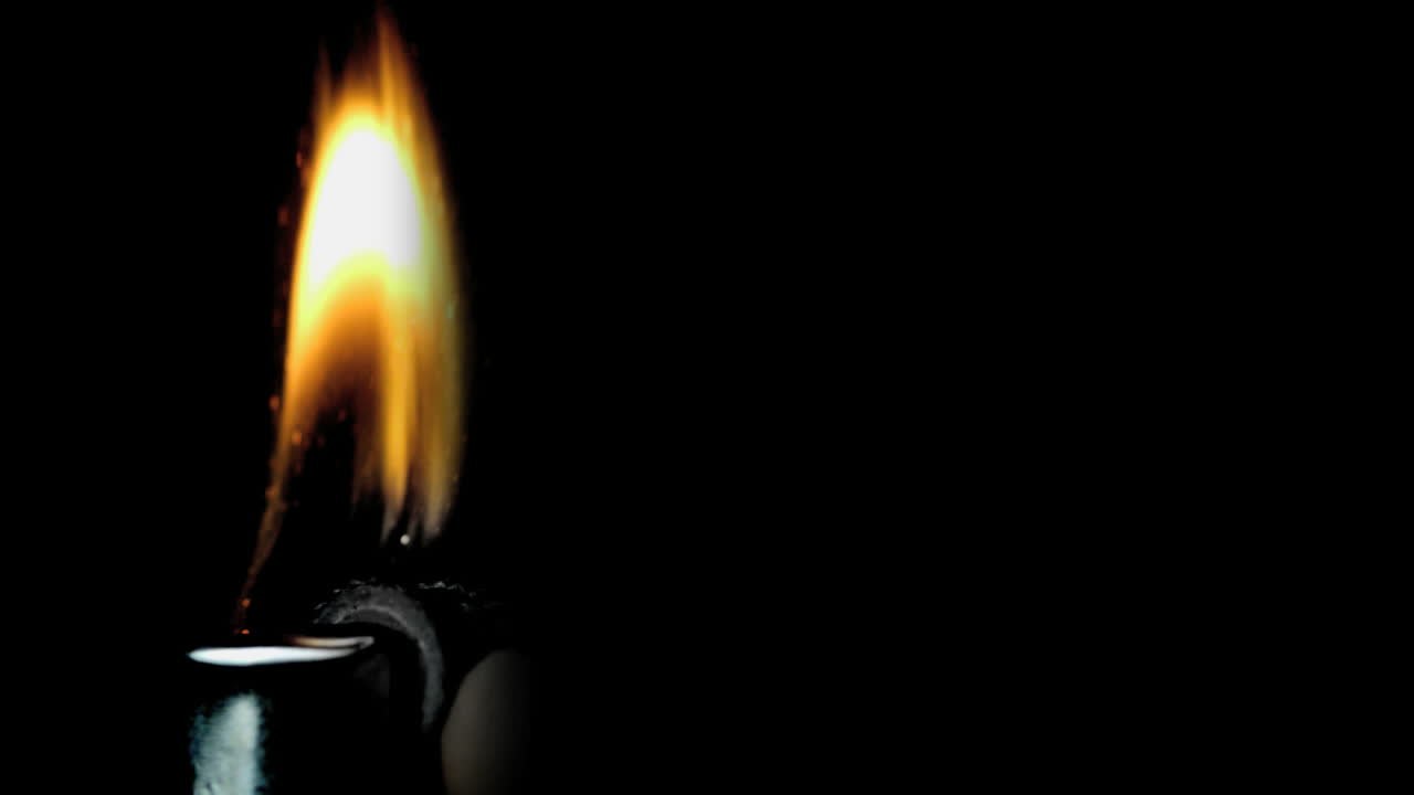 Hand using a lighter on black background