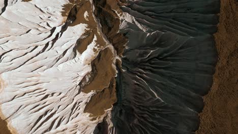 aerial view of eroded landscape with white and brown geological formations