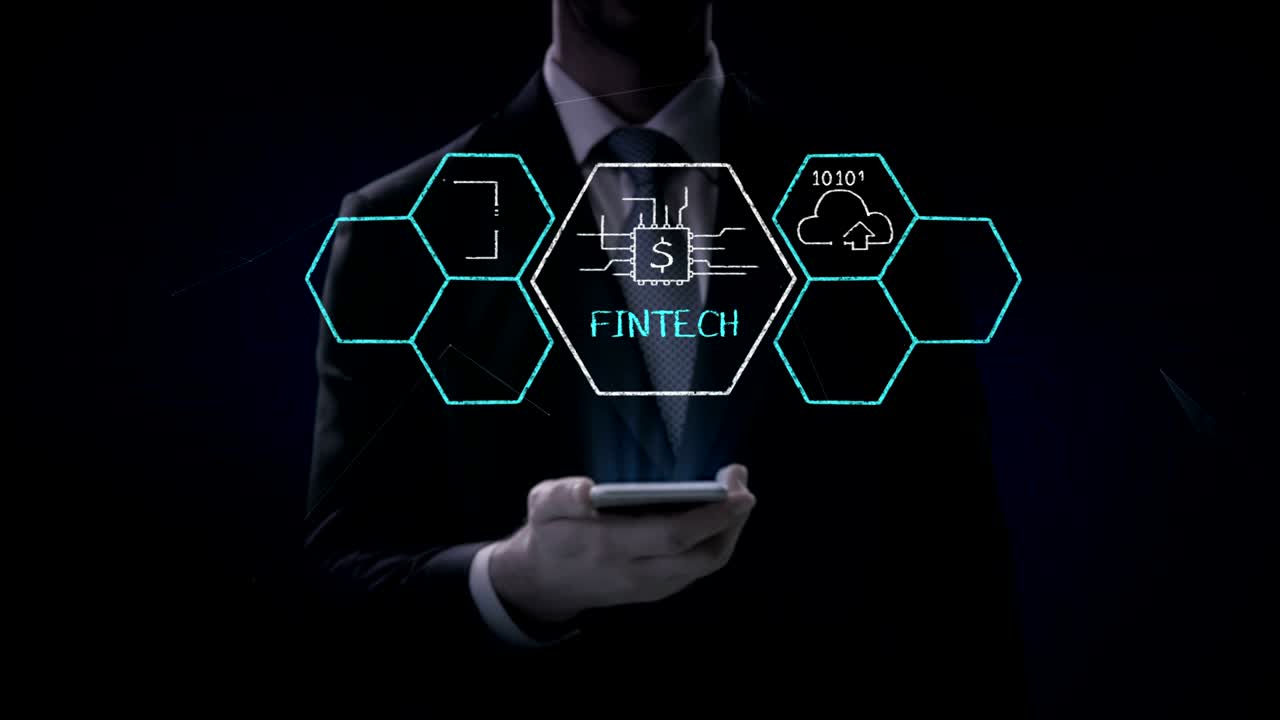Businessman lifting a smart phone, mobile, Fin-tech icon and various graph. Futuristic financial technology. 4k movie. version 1.