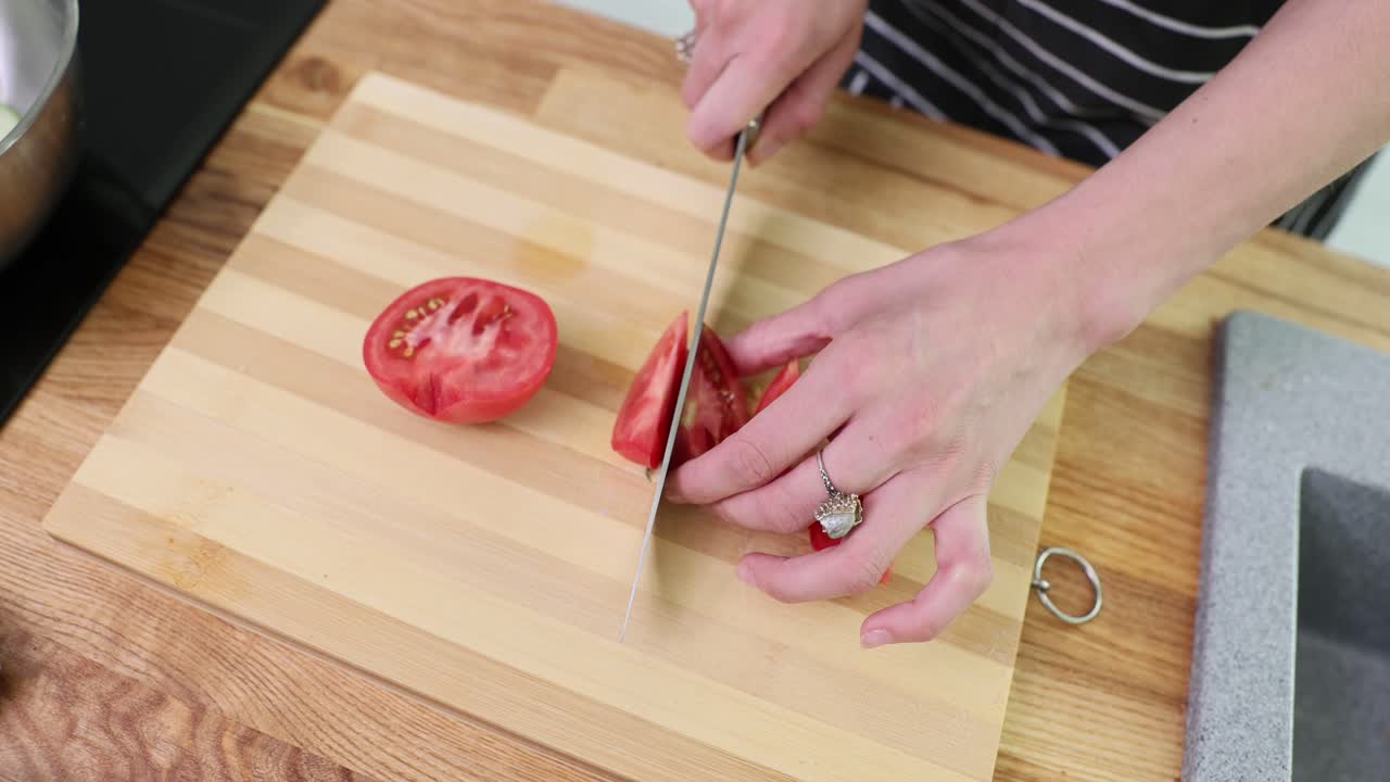 Person Slicing a Tomato on a Cutting Board