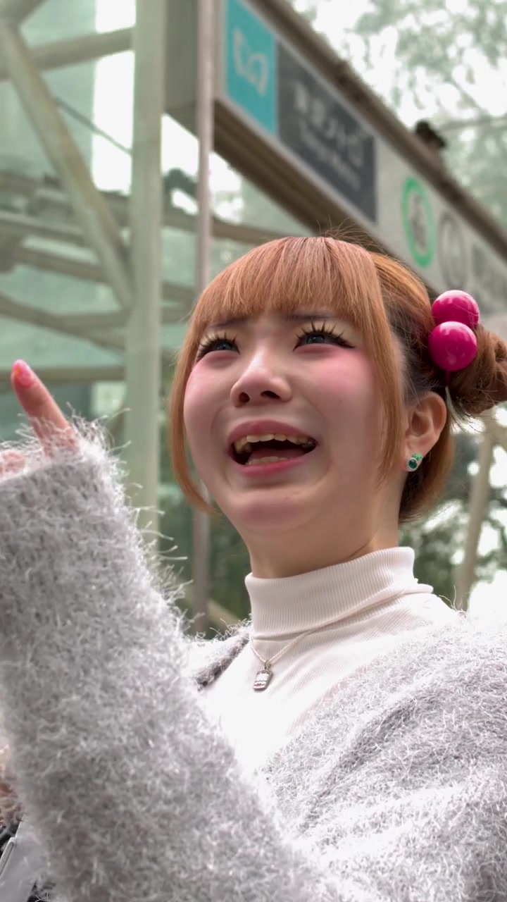 Una giovane donna con accessori per capelli colorati e trucco sorride all'aperto a Tokyo, Giappone