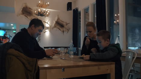 Familia-Pasando-La-Noche-De-Invierno-En-La-Cafetería