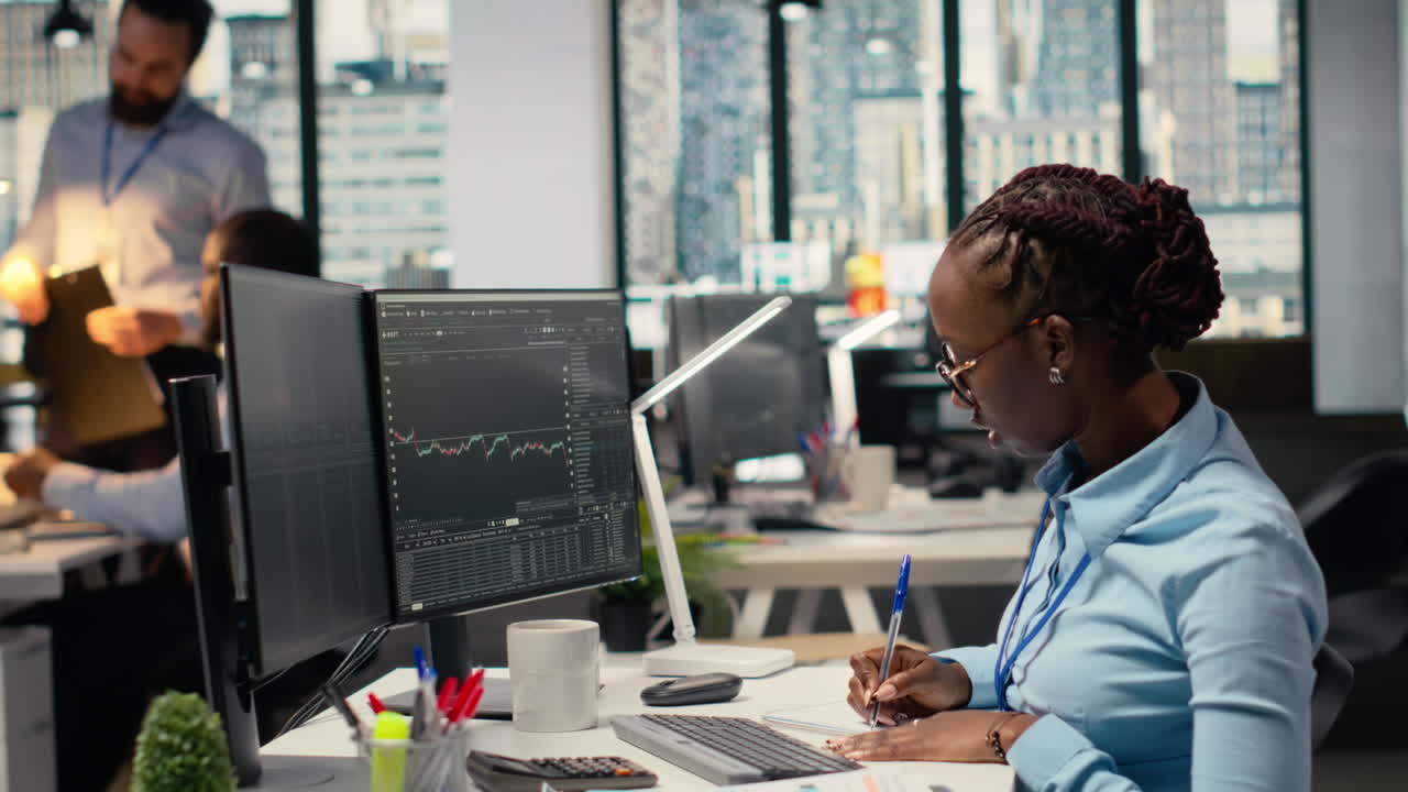 Day trader analyzes stock market price charts, taking notes