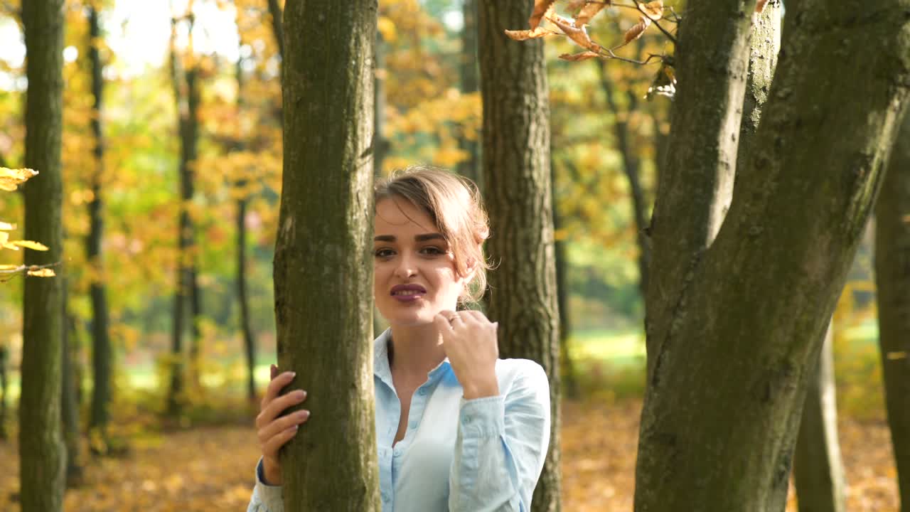 Fashion woman walking in autumn park. Outdoor fashion video of young beautiful lady surrounded autumn leaves