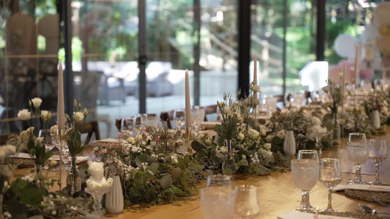 Elegant wedding table setup with white flowers, greenery, and crystal glassware