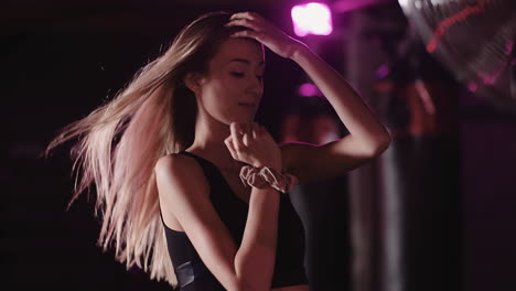 Slow-Motion-Of-Confident-Female-Athlete-Moving-Hand-Through-Hair-In-Gym