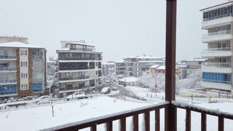 Snowy-day-in-Denizli,-Turkey,-showcasing-houses-and-traffic-on-the-road