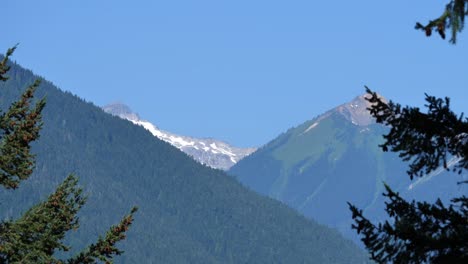 Forested-Mountains-With-Snow-Capped-At-The-Background-Over-Lillooet-Lake,-Squamish-Lillooet-In-British-Columbia,-Canada