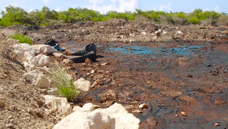 barriles con petróleo crudo y tanques de agua en la naturaleza