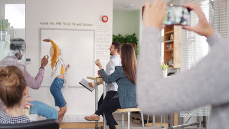 Crazy-happy-business-woman-dancing-doing-victory-dance-in-team-meeting-celebrating-success-achievement