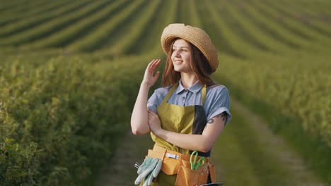 pretty woman in gardener work uniform posing and looking at camera