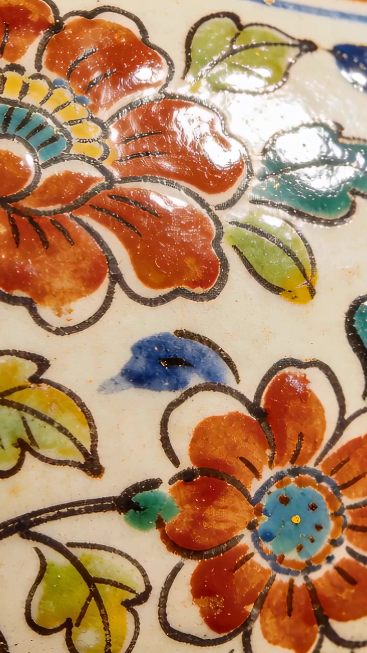 Vertical video: Panning, camera sliding over glazed plate at home to show flower detail
