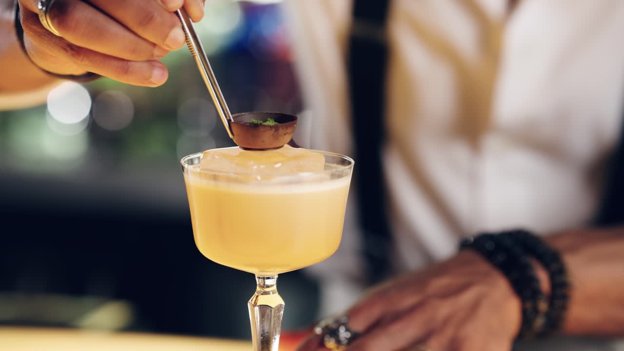 Barman professionista che aggiunge la guarnizione a un sofisticato cocktail