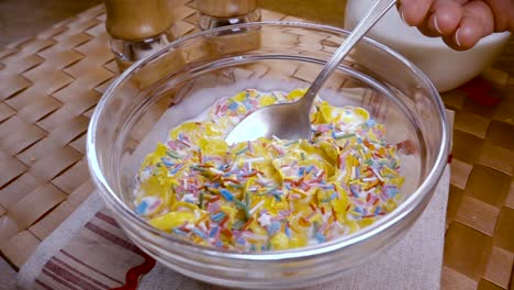 flocos de maíz amarillos crujientes en el cuenco para la mañana un delicioso desayuno con leche. cámara lenta con toma de seguimiento de rotación.