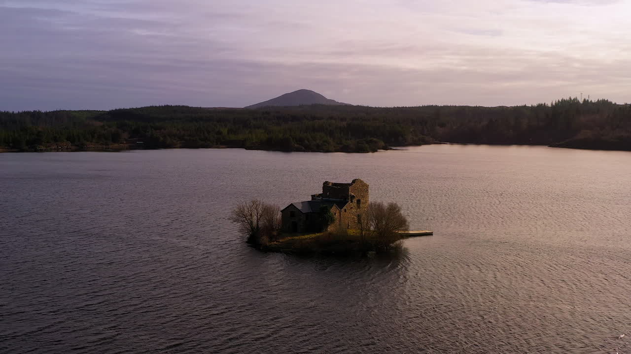 Aerial dolly of O'Flaherty Tower House bathed in soft evening light. Ireland