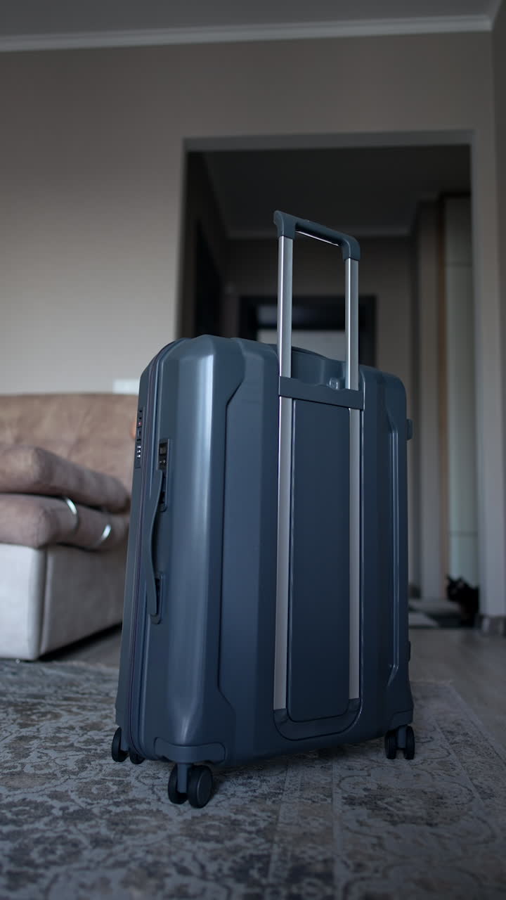 Lovely little boy wearing sunglasses enter the room pushing a big suitcase. Small toddler vacationer packing for journey. Vertical video.