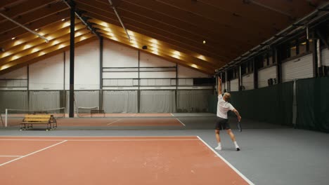 man playing tennis in an indoor court