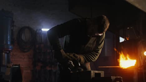 blacksmith grinding metal in a forge