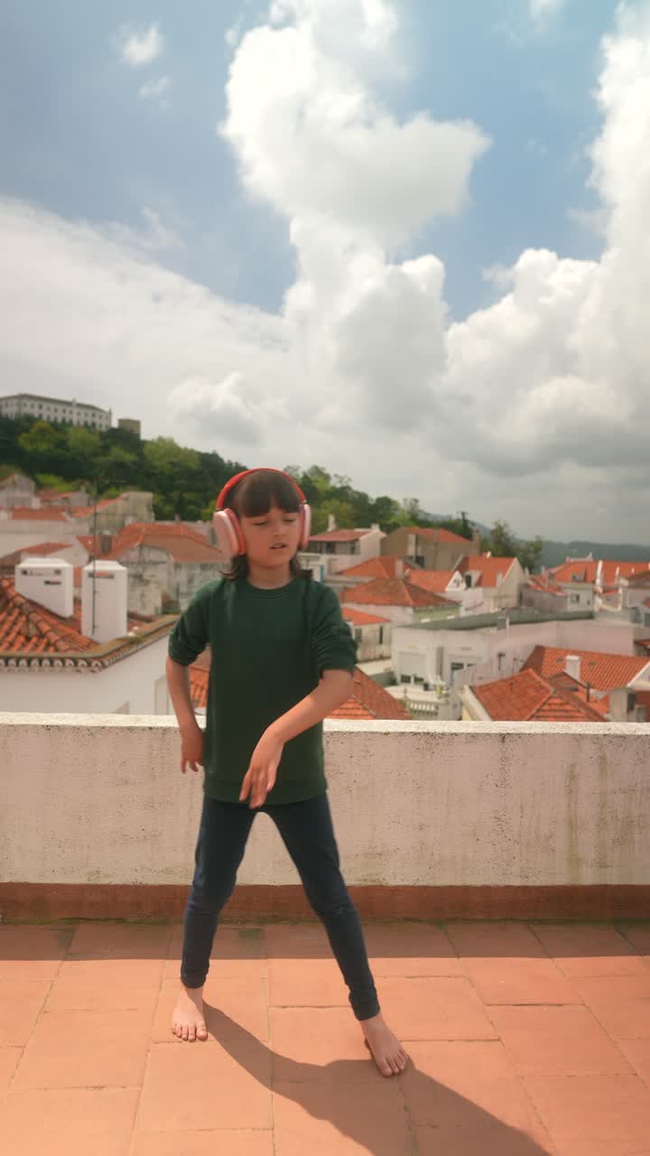 Happy Girl Dancing on a Rooftop with Headphones