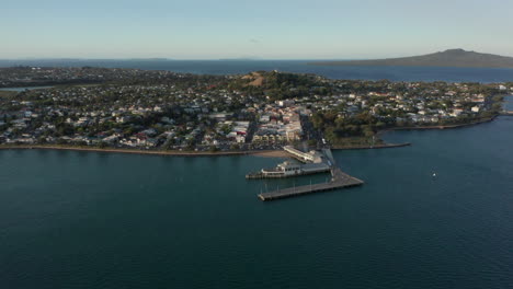 aerial view of the victorian style seaside village in devonport, auckland, new zealand surrounded by calm blue sea - drone shot