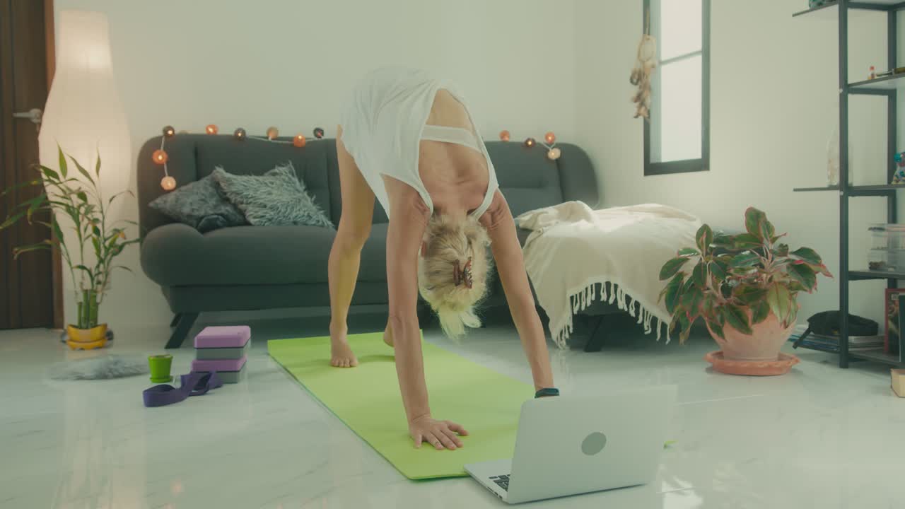 Woman doing yoga online at home