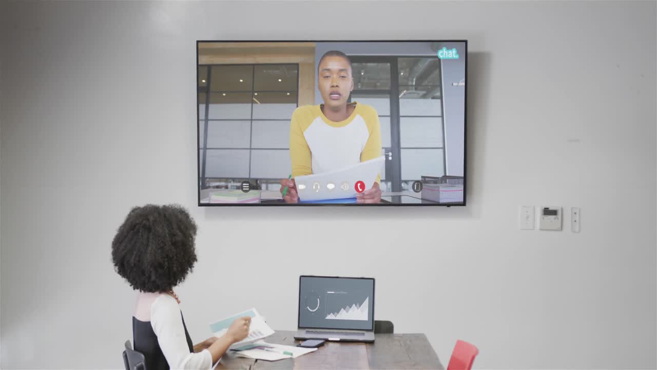 아프리카계 미국인 사업가 여성이 화면에서 아프리카계 미국인 남성 동료와 비디오 통화를 하고 있습니다.