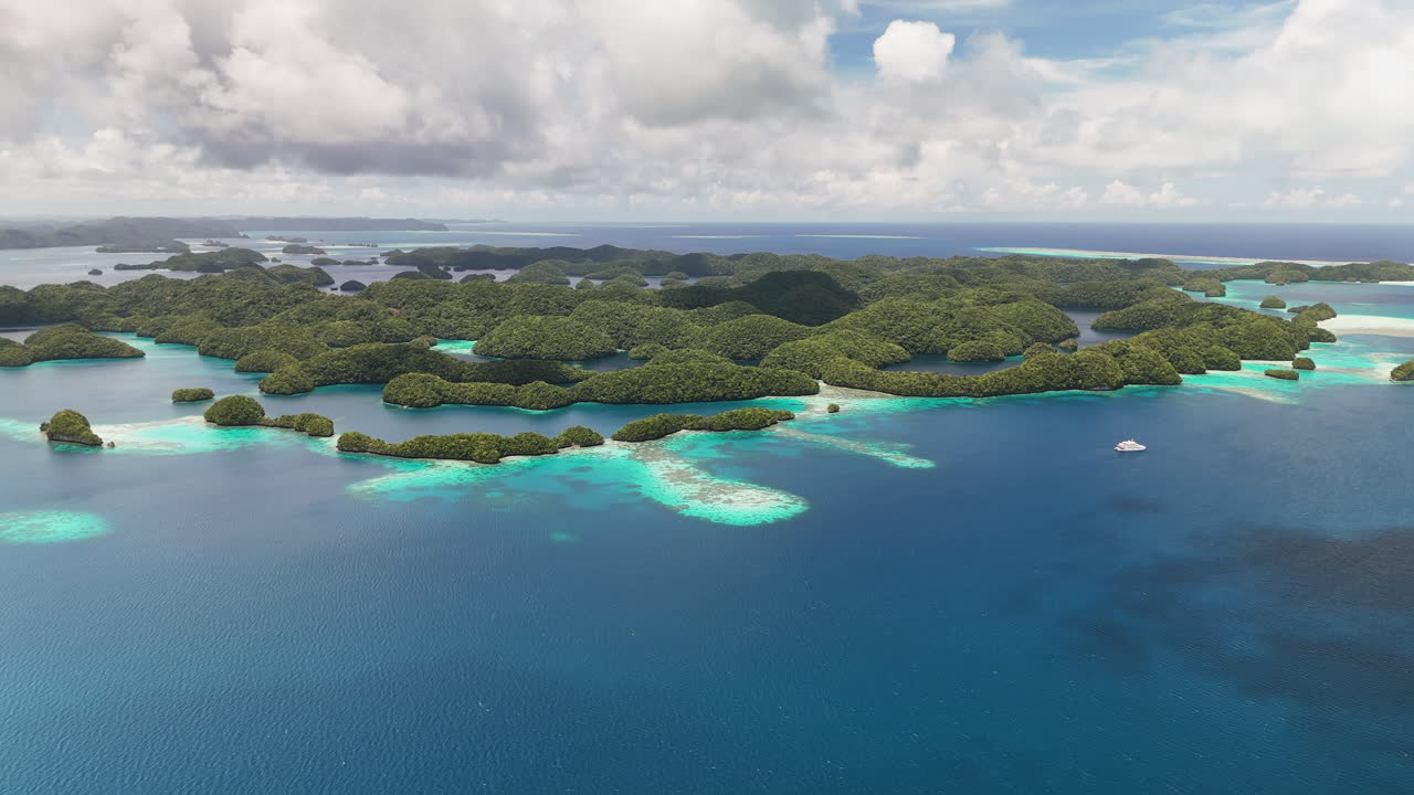 Fængslende droneoptagelse, der fejer hen over det uberørte turkise hav og frodige småøer omkring Palau. Bredt filmisk luftfoto