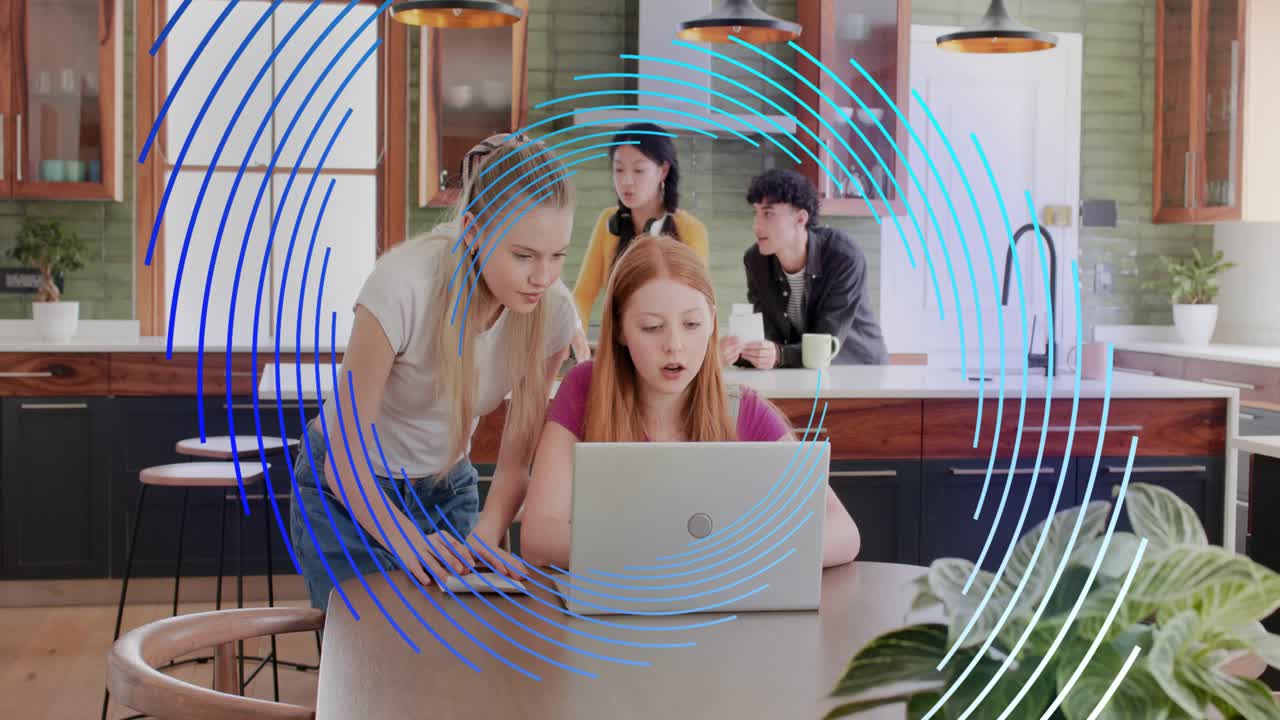 Five adults reviewing in kitchen, redhead opening laptop, others leaning, blue tech overlay moving