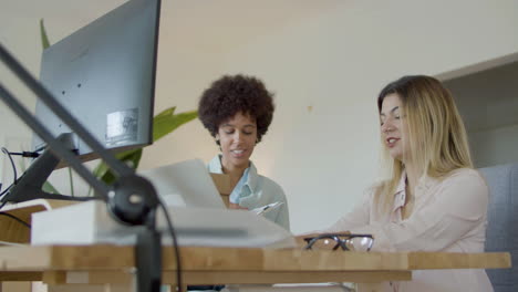 dos amigas trabajando en la oficina y charlando