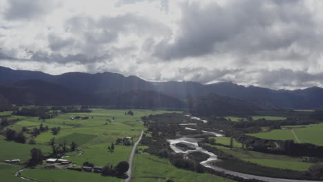 Aerial-drone-the-the-Grey-River-running-through-lush-green-landscape-near-Blackball,-New-Zealand