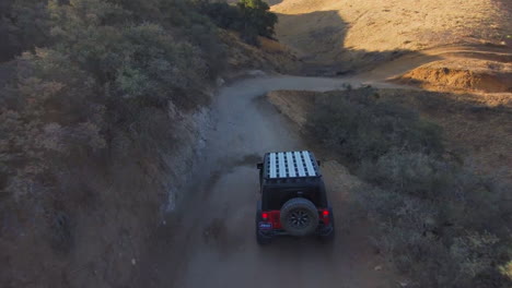 Toma-Aérea-De-Seguimiento-Cercano-Del-Jeep-Rojo-Que-Viaja-Fuera-De-La-Carretera