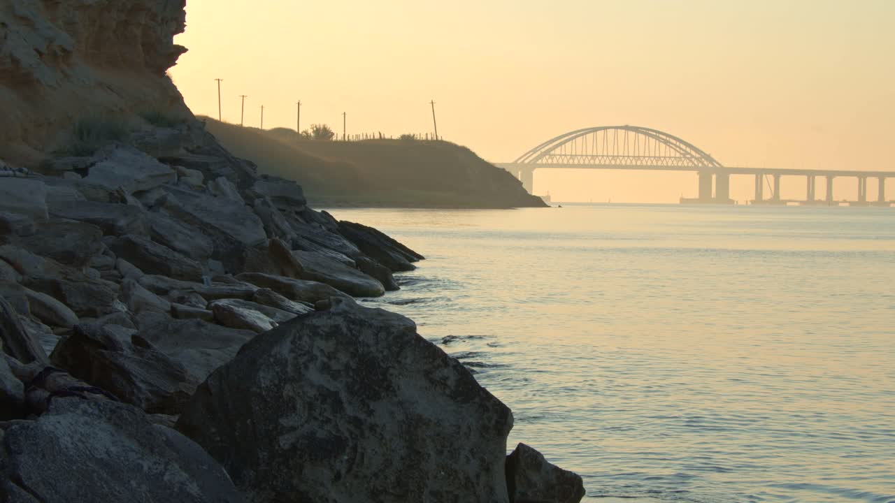 다리와 바위가 있는 강을 가로질러 해가 뜨는 것