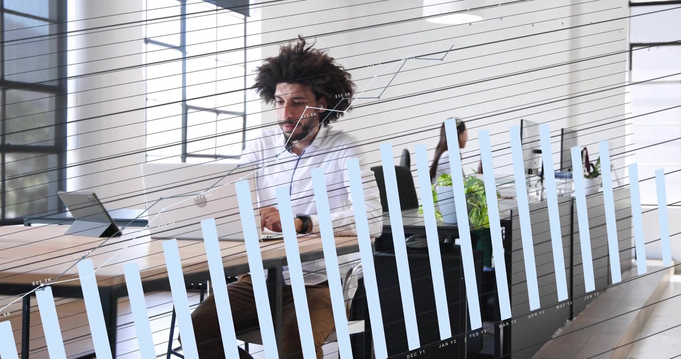 Man typing laptop in office as camera shifts, woman answering phone, frosted glass creating privacy