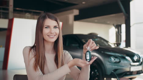 mujer recibiendo llaves de coche en un concesionario
