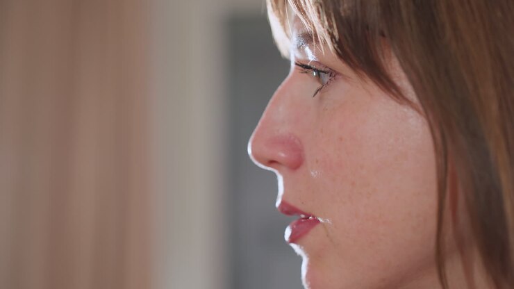 Close up of woman face speaking during counseling session, illuminated by soft studio light, revealing expressive eyes and lips, conveying empathy and attentiveness in professional wellness setting
