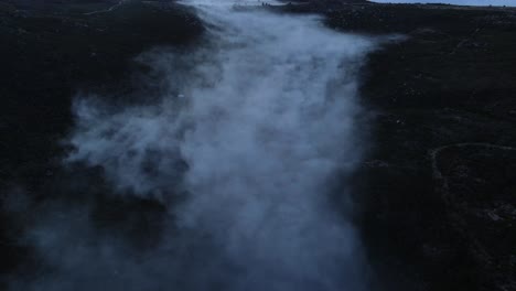 Aerial-view-of-a-beautiful-valley-covered-with-fog-and-clouds-drifting-away