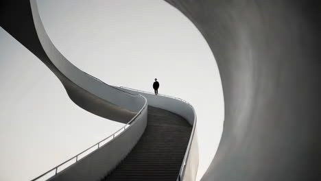 person standing on a modern curved architectural staircase