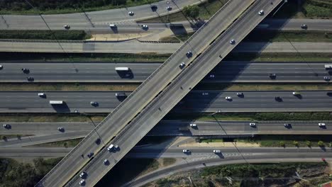 static aerial drone shot of busy highway interchange ramps with city traffic vehicles