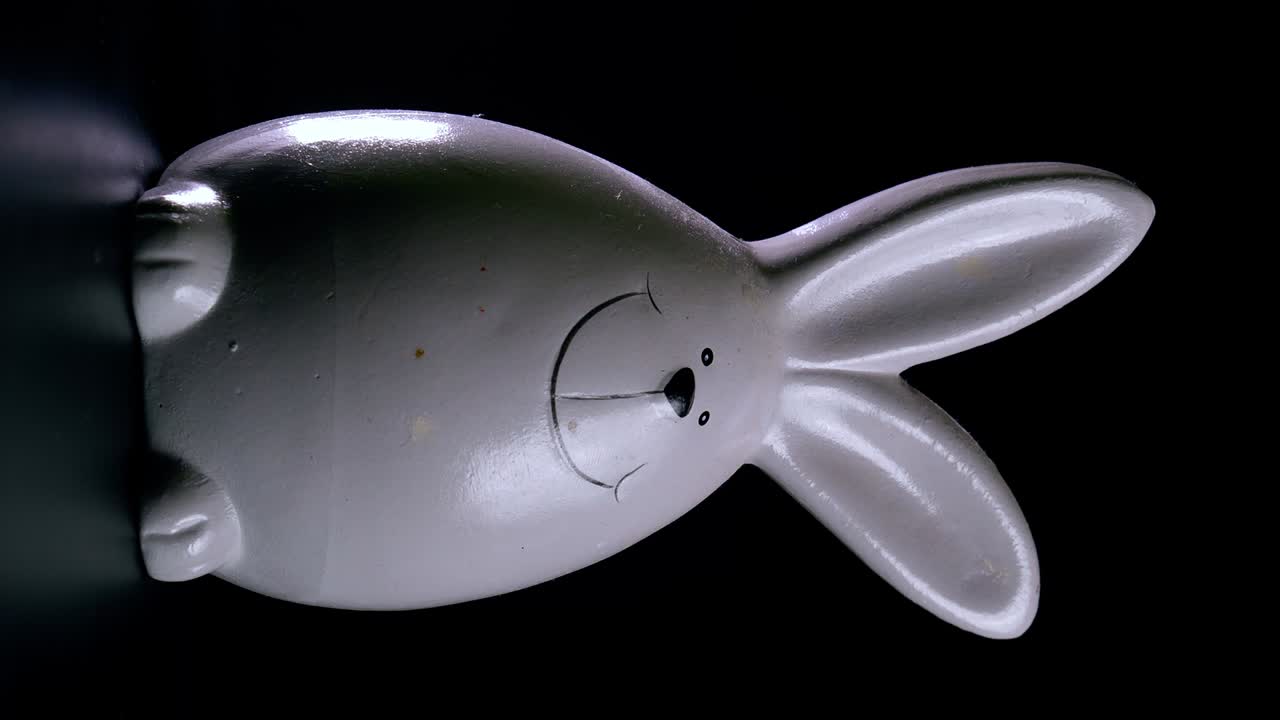 disparo estático de un conejo de pascua girando y riendo contra un fondo negro