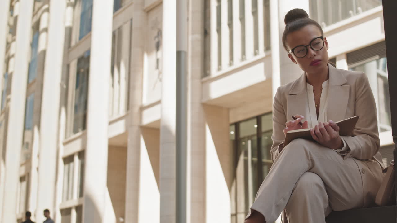 Woman Writing down Business Ideas in Planner Outdoors