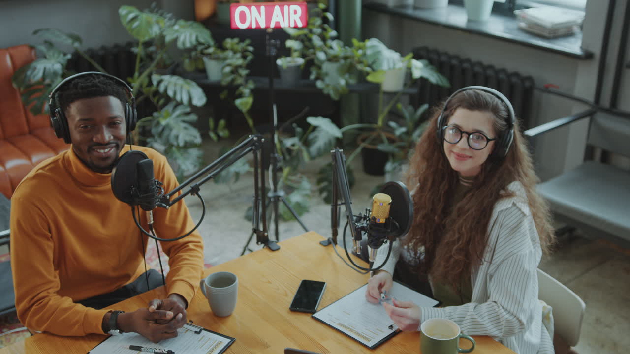 Portrait of Two Podcast Co-Hosts Smiling at Camera in Recording Studio