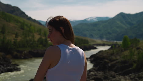 Lady-looks-at-curved-river-and-old-mountains-in-valley