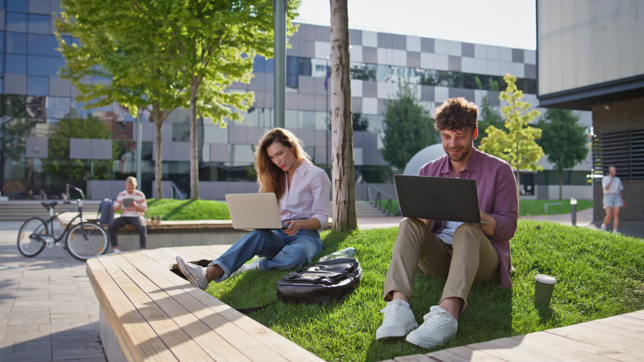 gerentes de startups navegando por la computadora portátil en el centro de negocios soleado. estudiantes centrados en el trabajo