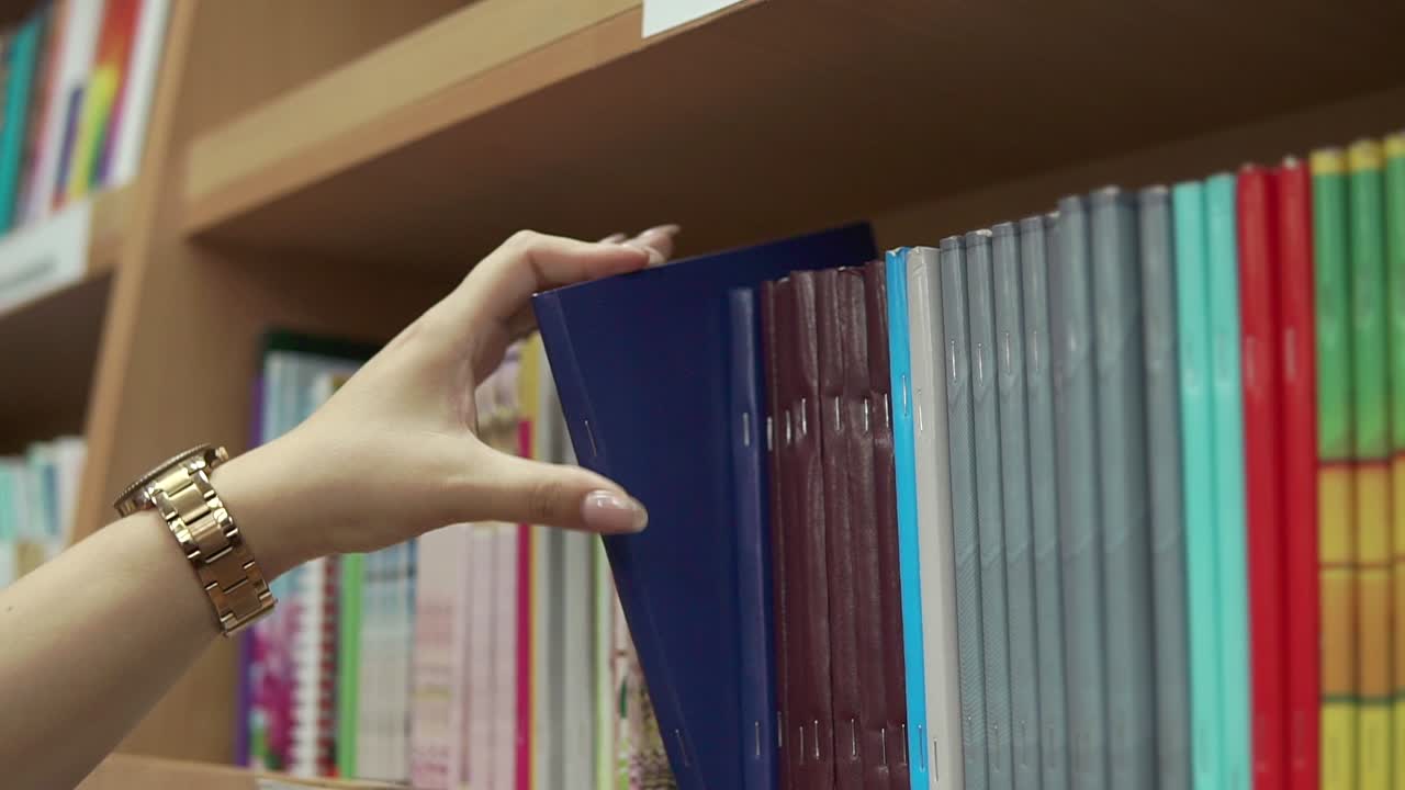 선반 에 있는 책 을 잡고 있는 여자